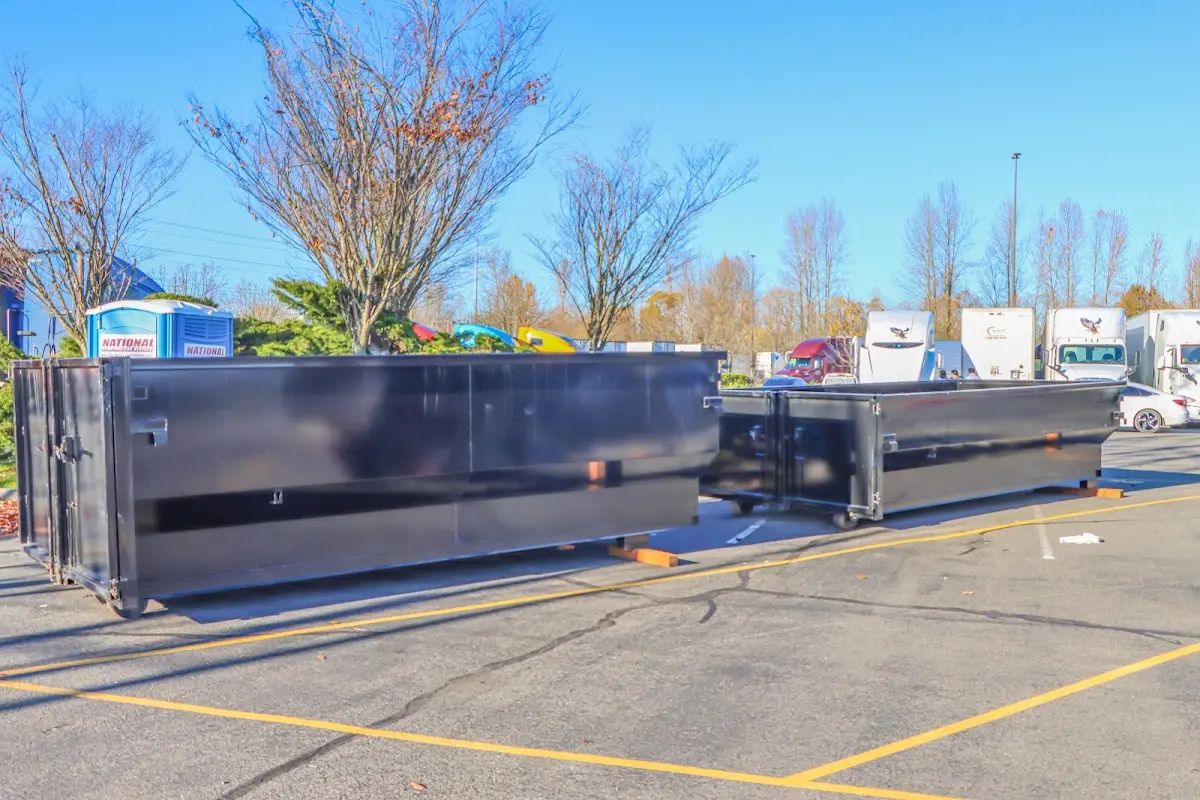 Professional dumpster rental service with roll-off container on residential driveway in Clayton